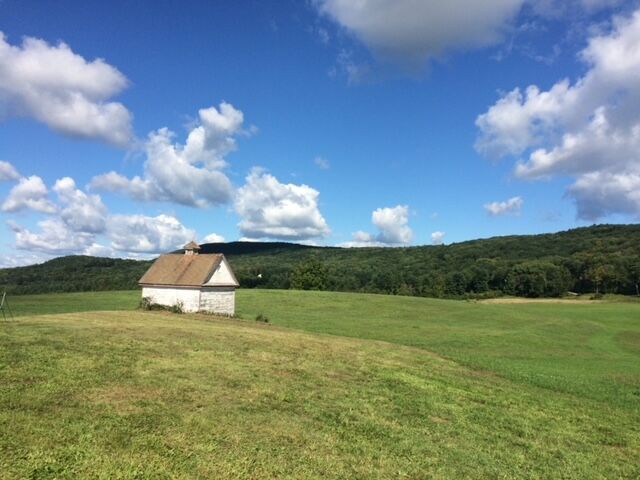 Farm shed under blue skies and puffy clouds